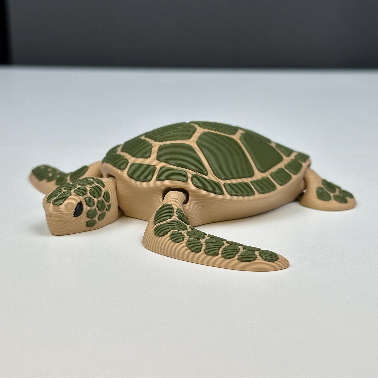 a 3d printed sea turtle. colored light brown and green.