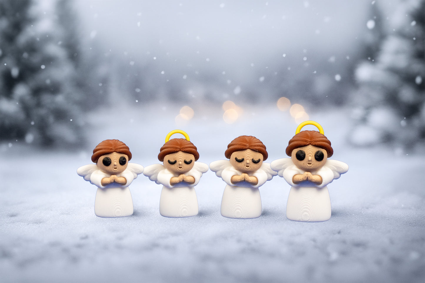 Four angel figurines in a snowy landscape with blurred trees in the background.